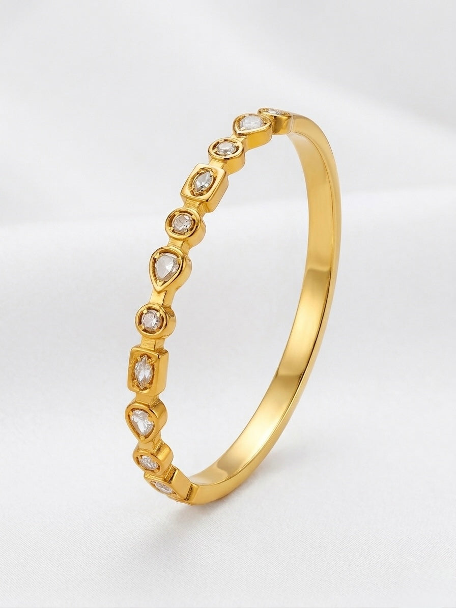Gold bracelet with heart-shaped diamond accents on a light gray background