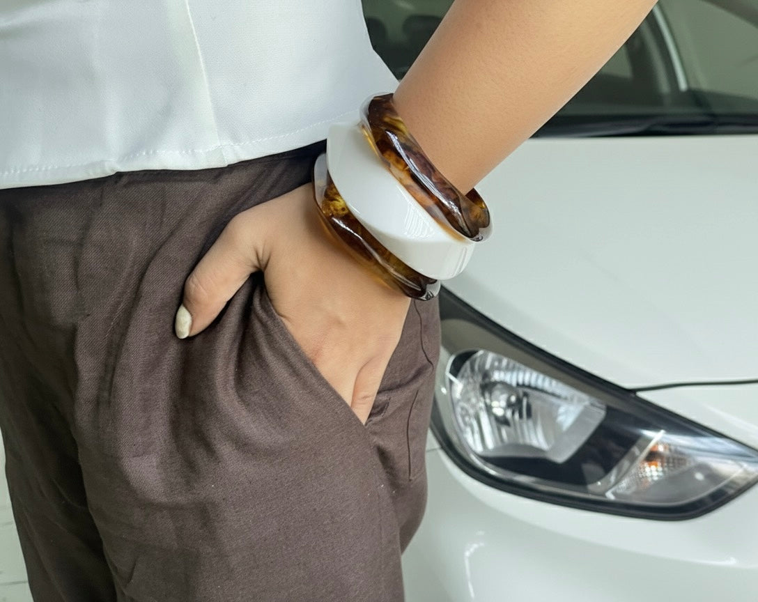Person wearing a tortoiseshell bracelet with a white background