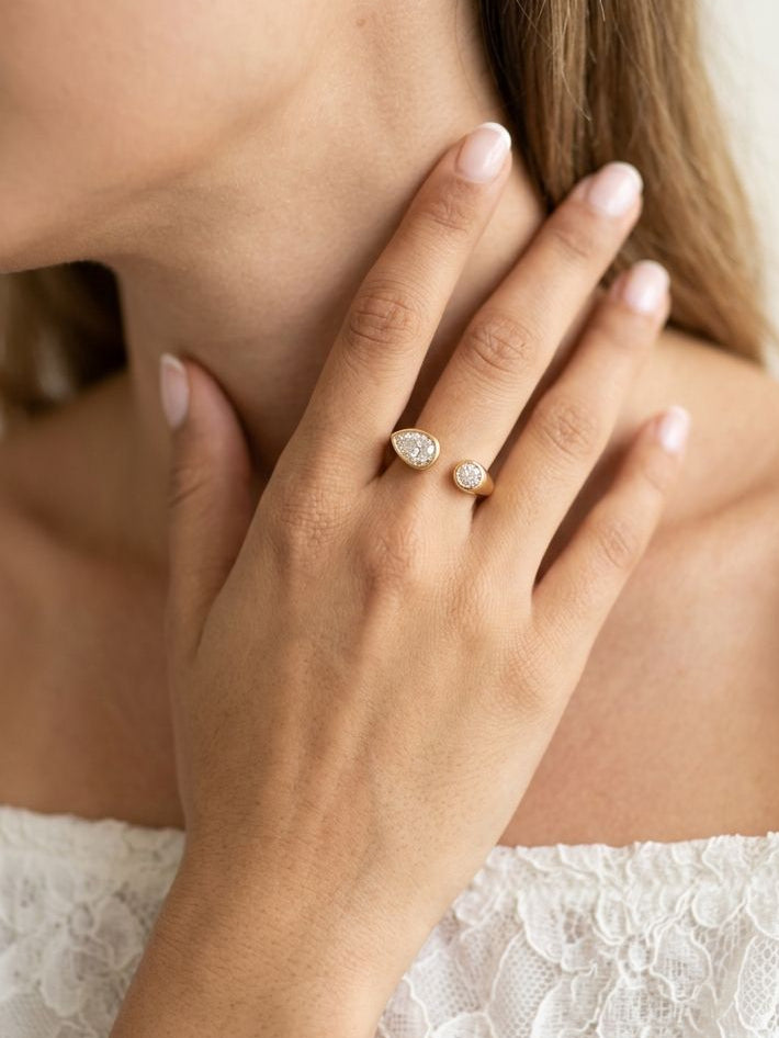 Close-up of a woman wearing a diamond ring on her hand, with a blurred background.